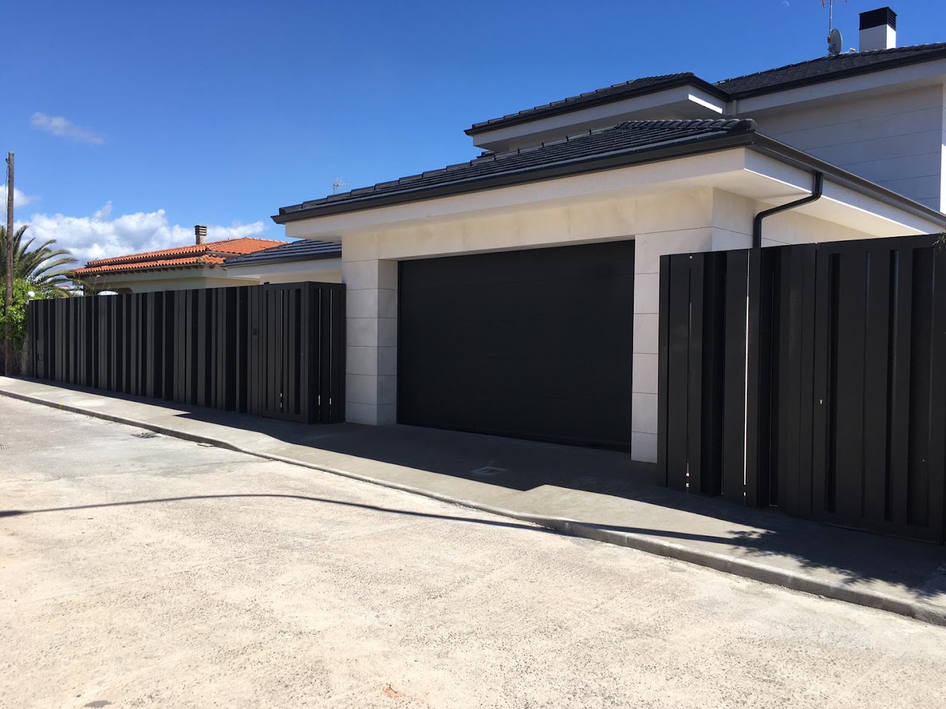 Cerramiento de lamas verticales y puerta de garaje en vivienda contemporánea