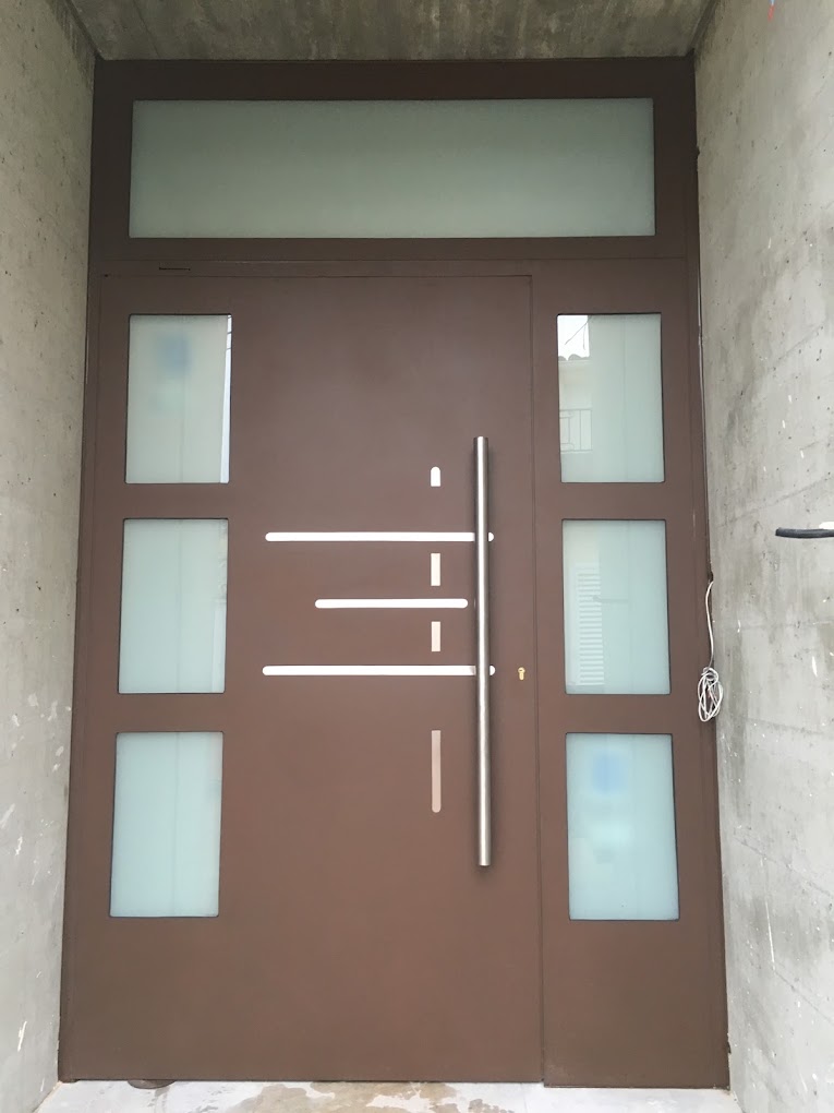 Puerta metálica contemporánea con paños de vidrio traslúcido
