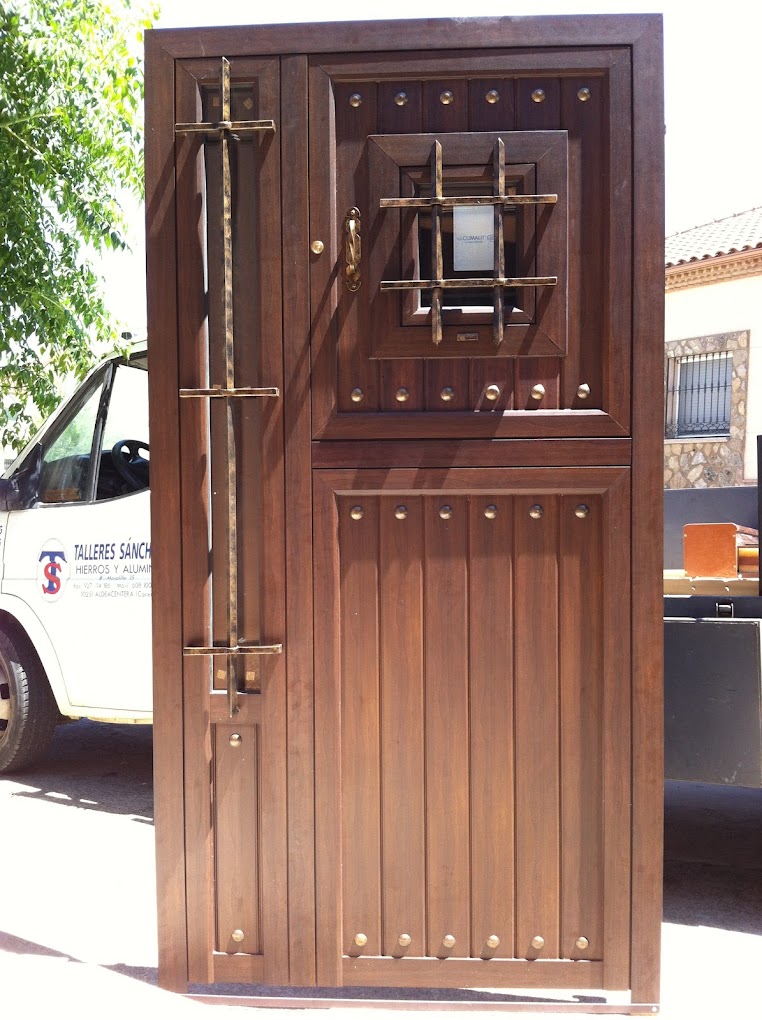 Puerta de cerrajería artística con acabado efecto madera y herrajes decorativos